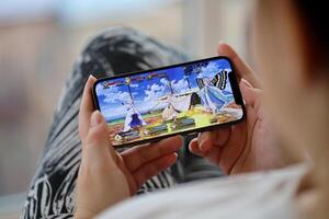 Fate Grand Order mobile iOS game on iPhone 15 smartphone screen in female hands during mobile gameplay photo
