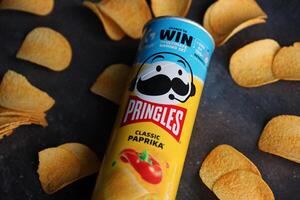 KYIV, UKRAINE - 4 MAY, 2023 Pringles tube of chips with rare classic paprika flavour photo