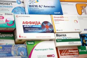 KYIV, UKRAINE - 4 MAY, 2023 Many boxes of pills and capsules stacked in pharmacy drug store photo