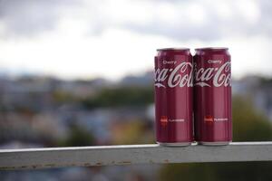 KYIV, UKRAINE - 4 MAY, 2023 Coca cola soft drinks brand tin cans with cherry flavour photo