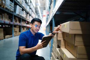 Asian warehouse worker uses tablet computer looking at merchandise. Logistics and export business Logistics distribution center. photo