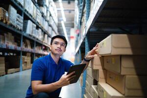 Warehouse workers in blue uniforms use digital tablets to check inventory in a large warehouse. Distribution center. Logistics and export business. photo