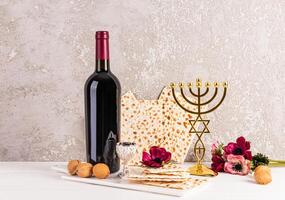 Beautiful festive still life for the Jewish Passover holiday. Front view of traditional foods, kosher wine in glass bottle , candlestick menorah photo