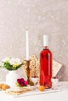 The concept of Jewish Passover. Traditional kosher food for the holiday, flowers in a vase. A burning candle in a candlestick. Vertical view. photo