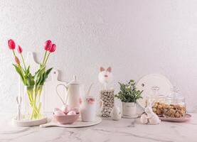 Stylish kitchen background for Easter holiday with traditional symbols and white tableware. foreground. Easter holiday concept. photo