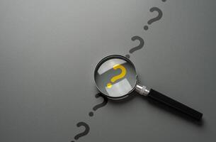 Magnifying glass and yellow question mark. FAQ. Solving mysteries, uncovering hidden truths. Curiosity, inquiry, uncertainty. Search for answers, clarity understanding. Quest for knowledge solutions photo