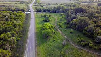 Haut vue de Autoroute avec voitures sur vert Contexte. agrafe. Piste passe par vert des arbres sur Contexte de des champs atteindre horizon. panorama Autoroute avec en mouvement voitures dans été video