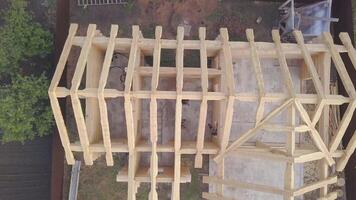 Top view of frame of wooden house under construction. Clip. Country wooden cottage built of logs is in stage of completion of frame. Construction works of private cottages video