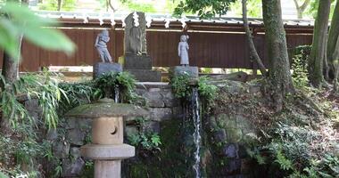 en religiös staty och vattenfall på de traditionell gata i sommar video