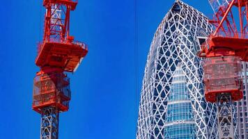 A timelapse of crane at the top of the building in Tokyo telephoto shot panning video