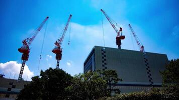 A timelapse of crane at the top of the building at the business town in Tokyo wide shot tilt video