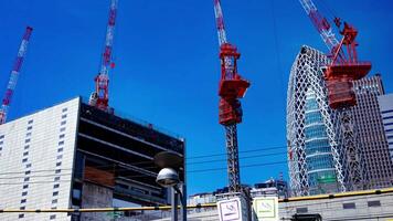 un' lasso di tempo di gru a il superiore di il edificio a il attività commerciale cittadina nel tokyo largo tiro panning video