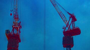 A timelapse of crane at the top of the building in Tokyo telephoto shot panning video