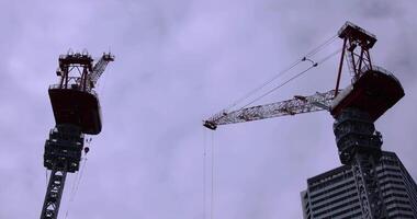 en mouvement grues à le en dessous de construction dans tokyo téléobjectif coup video