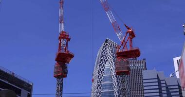 Moviente grúas a el parte superior de el edificio a el negocio pueblo en tokio video