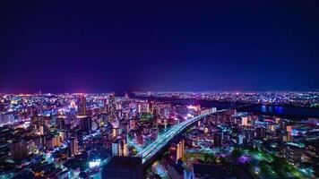 een nacht timelapse van stadsgezicht in de buurt jodo rivier- in Osaka breed schot kantelen video