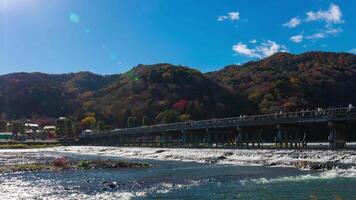 un lapso de tiempo de nube y turistas cerca togetsukyo puente en Kioto amplio Disparo enfocar video