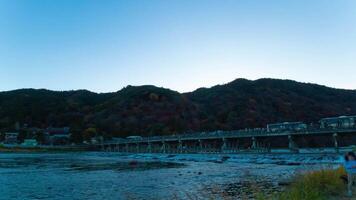 un oscuridad lapso de tiempo de togetsukyo puente en Kioto en otoño amplio Disparo inclinación video