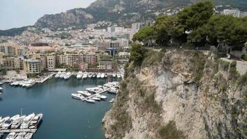Top view of pier with parked yachts on sea. Action. Beautiful landscape view from rocky coast to seaside town with port for yachts. Expensive yachts moored on coast of resort town video