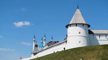 Mosque on a sunny summer day surrounded by high wall and a tower on blue cloudy sky background. Stock footage. Religion concept, Mosque and the fortress. video