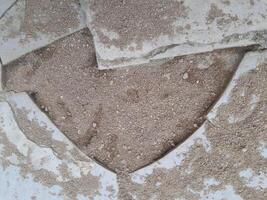 Photo of broken floor tiles filled with sand. Perfect for wallpaper, background, banner, web, advertising