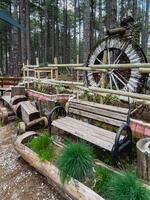 wooden benches and watermill in a forest photo