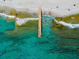 Aerial view of turquoise sea and beach with dock photo