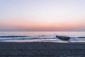 waves splashes on rock in sea shore photo