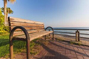 empty wooden bench on a beach photo