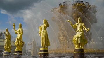 Gilded statues on background of fountain. Action. Beautiful Golden statues of women Shine on background of splashing large fountain video