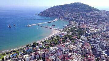 Top view of port of resort town on mountain. Clip. Beautiful seaport with floating ships off coast of resort town. Port resort town on background of green mountains and sea horizon video