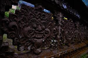 a carved stone temple fence with a carved face on it photo