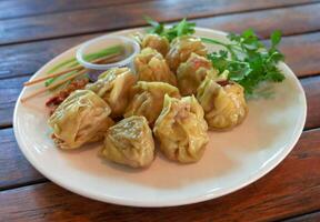 streamed dumplings with sauce on dish photo