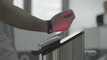 Man applying RFID bracelet to the electronic access equipment on entrance gate to the subway, underground or gym. Frame. Black electronic bracelet for access to the subway, underground or fitness video