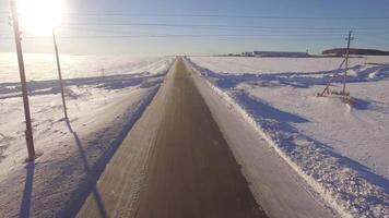 aérien routes. suv conduite dans blanc neigeux à feuilles persistantes forêt sur glissant asphalte route. aérien vue de le route et le des champs dans le hiver video