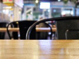 cerca arriba superficie de de madera mesa en café con bokeh antecedentes. selectivo atención foto