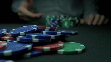 Close-Up of Man Throwing a Poker Chips in slow motion. Close-up of hand with throwing gambling chips on black background. Poker player increasing his stakes throwing tokens onto the gaming table. video