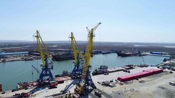 Aerial loading the Containers by crane , Trade Port , Shipping. Cranes for loading, unloading and sorting of containers. Container Cargo freight ship with working crane bridge in shipyard at dusk for video