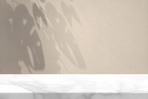 White Marble Table with Monstera Leaf on Concrete Wall Texture Background in Set Sail Champagne Color Tone, Suitable for Product Presentation Backdrop, Display, and Mock up. photo