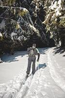 Middle-aged cross-country skier aged 50-55 makes his own track in deep snow in the wilderness in the morning sunny weather in Beskydy mountains, Czech Republic photo