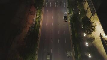 Top view of street with cars and modern buildings in big Chinese city at night. Shot. Night aerial view of city center with its road, moving cars, lights of skyscrapers, night life concept. video