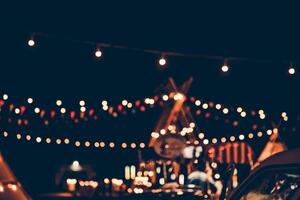 Blurred images of the background party in the festive festivities during the night, consisting of people and glittering bokeh. photo