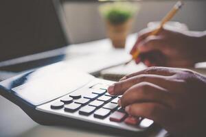 Businessman are working with a calculator and document. Meeting report in progress. in office business concept photo