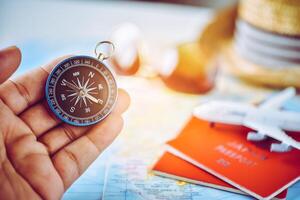 Tourists hold a compass and locate a place on a world map. photo