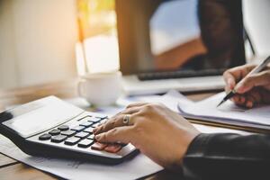 Businessman are working with a calculator and document. Meeting report in progress. in office business concept photo