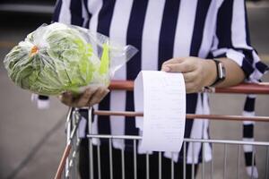 The woman who handles the receipt and the check in the shopping cart bought from the mall. photo