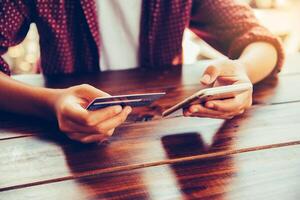 Woman holding credit cards and mobile phones are now shopping over the internet by paying by credit card. photo