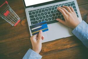 Woman holding credit cards and mobile phones are now shopping over the internet by paying by credit card. photo