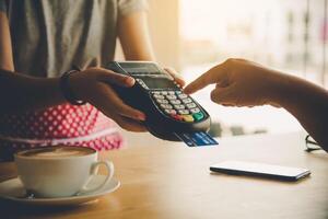 Close up of hand using credit card to pay by sending the credit card to the staff at the credit card swipe machine. Online payment photo