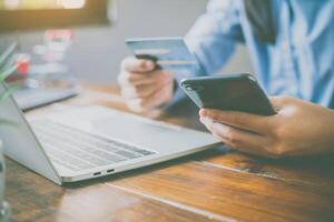 Woman holding credit cards and mobile phones are now shopping over the internet by paying by credit card. photo